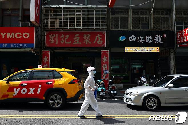 2021년 6월 2일 대만 타이페이에서 코로나19 확진자 수가 급증하고 있는 가운데 한 남성이 방호복을 입고 거리를 거닐고 있다. © 로이터=뉴스1 © News1 정윤영 기자