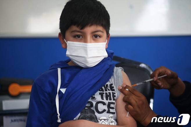 9일(현지시간) 볼리비아 라파스에 마련된 코로나19 백신 접종소에서 어린이가 중국산 시노팜 백신을 맞고 있다/사진=AFP