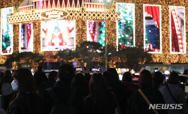 [서울=뉴시스] 권창회 기자 = 크리스마스를 보름 정도 앞둔 9일 오후 서울 중구 신세계백화점 본점 인근이 크리스마스 미디어 파사드를 찍기 위한 시민들로 붐비고 있다. 2021.12.09. kch0523@newsis.com
