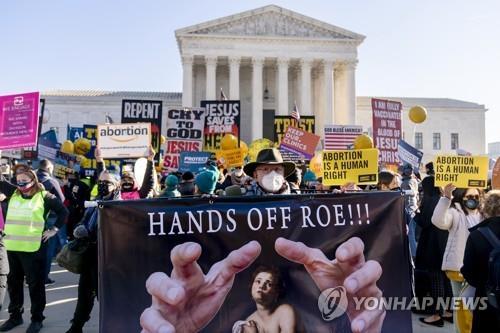 낙태 지지자의 외침…"'로'에게서 손을 떼라!" 지난 1일(현지시간) 미국 워싱턴DC 연방대법원 앞에서 낙태권 지지자 스티븐 팔라토가 "'로'에게서 손을 떼라"는 문구가 적힌 현수막을 들고 서 있다. 로는 '로 대(對) 웨이드'로 불리는 1973년 연방대법원 판결의 주인공이 쓴 익명으로, 당시 낙태를 형법으로 금했던 텍사스주에서 낙태를 시도했던 여성을 뜻한다. [AP 연합뉴스 자료사진. 재판매 및 DB 금지]