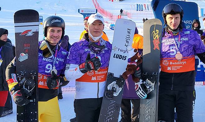 이상호(가운데)가 11일 러시아 반노예에서 열린 2021~2022 FIS 스노보드 월드컵 남자 알파인 평행 대회전 결승에서 한국 설상 최초의 월드컵 우승을 차지한 뒤 준우승자인 슈테판 바우마이스터(왼쪽), 3위 안드레이 소블레프와 기념촬영을 하고 있다. 대한스키협회 제공