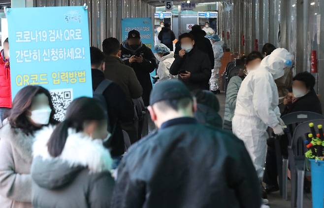 13일 서울 동대문구 보건소 코로나19 선별진료소에서 시민들이 검사를 받기 위해 큐알코드 등록 등을 하며 순서를 기다리고 있다. 뉴시스