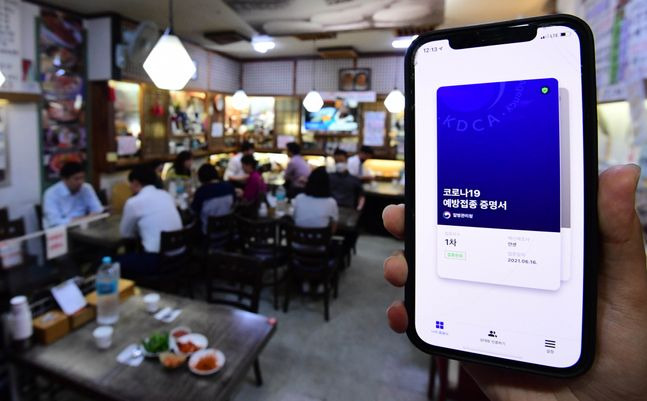지난 7월 서울 광화문의 한 음식점에서 백신 접종을 완료한 한 시민이 식사에 앞서COOV앱으로 코로나19예방접종 증명서를 보이고 있다. ⓒ데일리안 류영주 기자