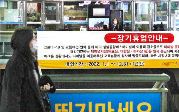 코로나19에 따른 승객 감소 등을 이유로 경기도 성남시의 유일한 고속버스터미널인 성남종합버스터미널이 내년 1월 1일부터 1년간 장기휴업을 신청했다고 14일 밝혔다. 코로나19 확산 이전에는 26개 운수업체의 54개 노선을 하루 평균 7000여 명이 이용했으나 현재는 2000여 명에도 미치지 못하는 것으로 알려졌다. 성남시에서는 터미널 운영사에 대한 지원 방안 협의에 나섰다. 이날 장기휴업을 알리는 현수막 앞을 한 시민이 지나가고 있다. [박형기 기자]