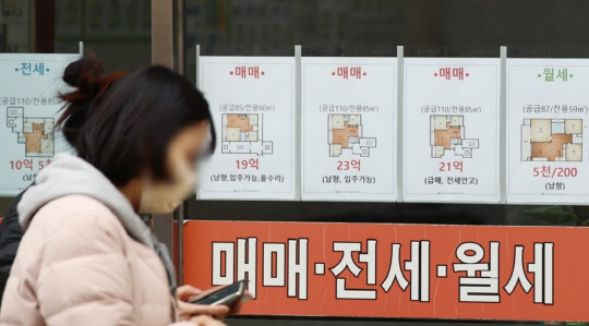 한 시민이 부동산 매물정보가 걸려 있는 중개업소 게시판 앞을 지나가고 있다. <연합뉴스>