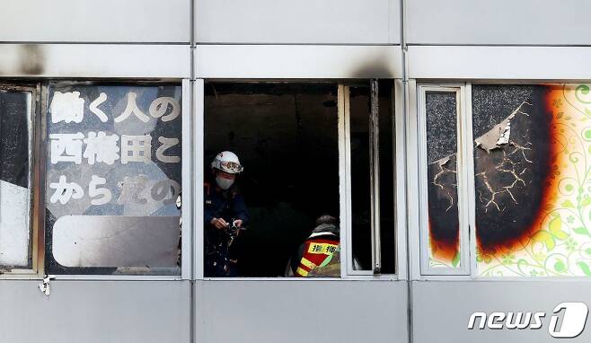 17일(현지시간) 일본 오사카의 한 건물에서 발생한 화재로 27명이 의식불명인 가운데 현장에서 소방 인력이 작업 중이다. 2021.12.17/news1 © AFP=뉴스1 © News1 김민수 기자