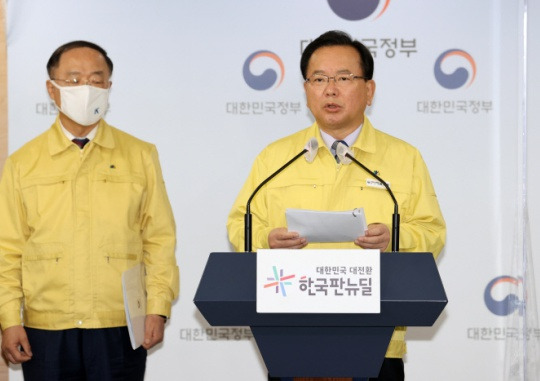 Prime Minister Kim Boo-kyum (right) and Deputy Prime Minister Hong Nam-ki give a briefing on government support for small and self-employed business owners following stronger distancing measures at the joint briefing room in the government office building in Seoul on December 17. Yonhap News