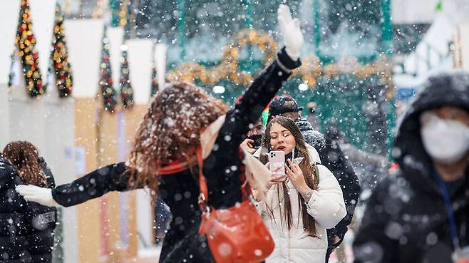 18일 오후 서울 홍대거리에서 외국인들이 눈을 맞으며 사진을 찍고 있다.