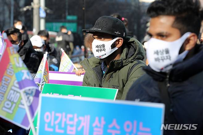 [서울=뉴시스] 백동현 기자 = 이주노동자노동조합 조합원들이 19일 오후 서울 종로구 보신각 앞에서 열린 세계이주노동자의날 결의대회에 참가해 '불평등 세상을 바꾸자' 문구가 적힌 마스크를 쓰고 있다. 2021.12.19. livertrent@newsis.com