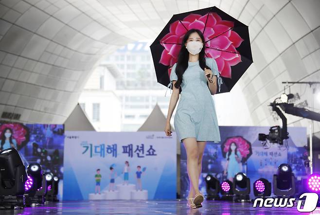 지난 7월 서울 중구 동대문디자인플라자에서 열린 시민과 함께하는 '기대해(기후위기 대응해요) 패션쇼'에서 시민 모델이 런웨이를 하는 모습. 이날 패션쇼에서는 여름철 간편한 옷차림인 시원차림과 면, 선인장가죽 등을 활용한 탄소배출이 적은 자연소재 의류, 폐폐트병을 재활용해 만든 리사이클 섬유 의류 등 폐자원 선순환을 통해 기후위기에 대응할 수 있는 다양한 옷차림이 공개됐다. 2021.7.9/뉴스1 © News1 권현진 기자