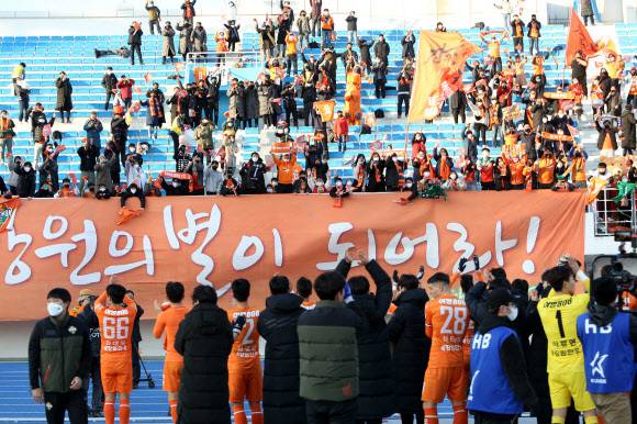 강원FC 선수들이 지난 12일 오후 강원 강릉시 강릉종합운동장에서 열린 하나원큐 K리그1(1부리그) 2021 승강 플레이오프 2차전 대전하나시티즌과의 경기에서 4-1 승리로 1부리그 잔류가 확정되자 팬들에게 인사하고 있다. 강릉=뉴시스