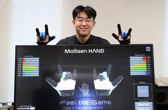 배준범 필더세임 대표가 장갑형 컨트롤러(몰리센 핸드)를 시연하고 있다. 이 장갑은 다섯 손가락의 관절부위마다 10개의 소프트센서가 손동작을 읽어 화면에 구현한다. 송봉근 기자