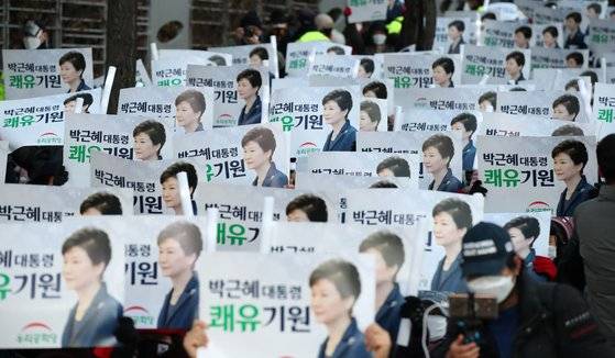 24일 오후 서울 강남구 삼성서울병원 앞에서 열린 박근혜 전 대통령 석방 축하 및 건강 기원 집회(제215차 태극기집회)에서 지지자들이 박 전 대통령 얼굴이 그려진 손 피켓을 들고 있다. 뉴시스