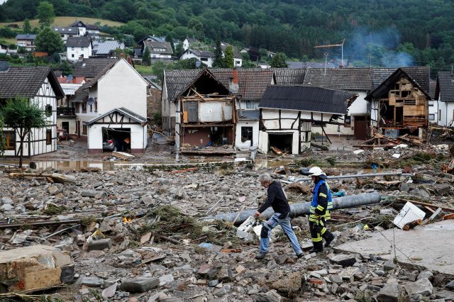 독일 서부 슐트에서 지난 7월 15일(현지시간) 폭우와 홍수가 휩쓸고 간 주택가의 잔해 사이를 소방관과 주민이 걸어가고 있다. 연합뉴스