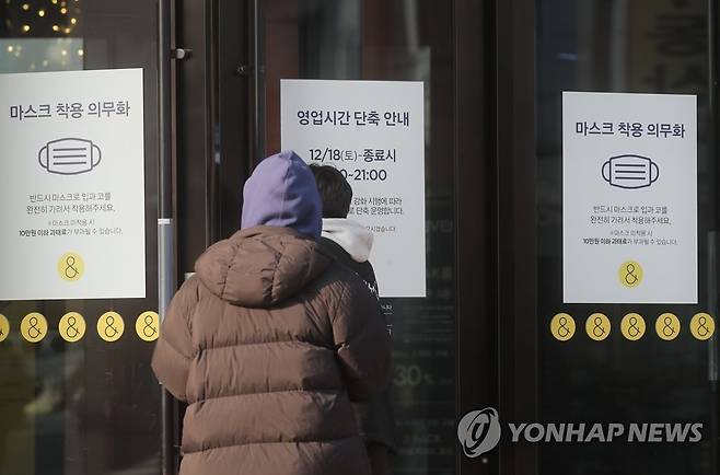 사회적 거리두기 2주 연장 가능성 (서울=연합뉴스) 류효림 기자 = 더불어민주당과 정부가 29일 코로나19 방역을 위한 거리두기 연장 필요성에 공감했다고 밝혔다.
사진은 이날 서울 시내 한 쇼핑몰에 부착된 영업시간, 방역패스 안내문 모습. 2021.12.29 ryousanta@yna.co.kr
