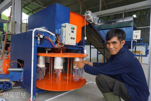 버섯 배지 원료를 섞어 12개씩 밀봉하는 기계가 인도네시아 족자 블레베란 마을에 설치됐다. 블레베란=고찬유 특파원