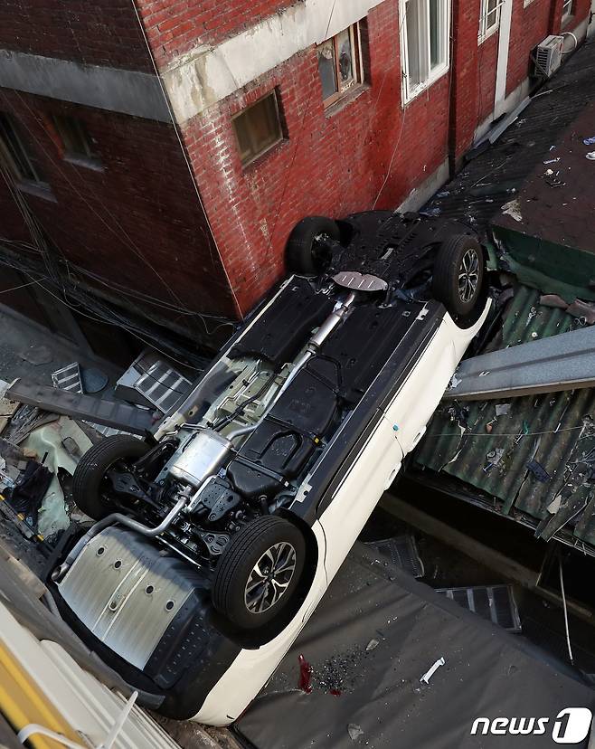 6일 오전 8시 30분께 서울 중구 숭례문 인근에 있는 한 민영 주차장에서 차량 1대가 야외로 추락해 지붕에 걸쳐져 있다.  2022.1.6/뉴스1 © News1 김명섭 기자