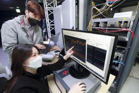 서울 KT 융합기술원에 구축된 Open RAN 테스트베드에서 KT 연구원과 후지쯔 연구원이 멀티벤더 연동 시험을 진행하는 모습.