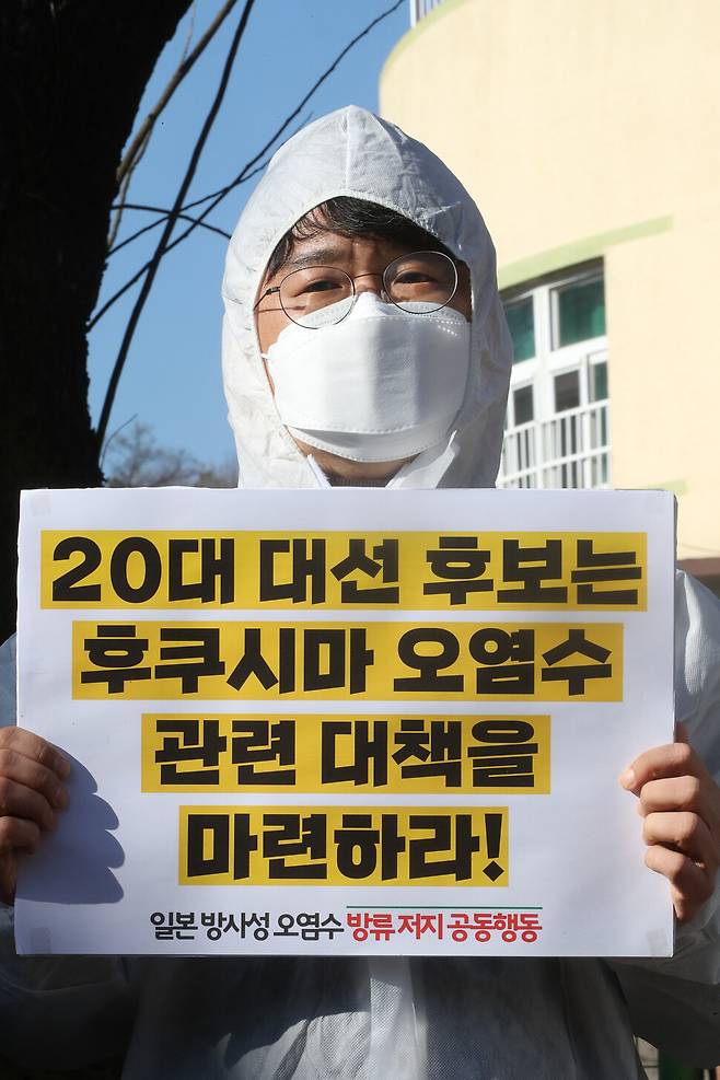 방호복을 입은 한 참석자가 20대 대선 후보들에게 후쿠시마 방사성 오염수 해양 방류에 대한 의견을 밝힐 것을 촉구하고 있다. 김태형 기자