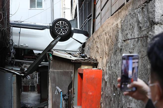 6일 오전 서울 중구의 한 주차장 건물에서 차량이 추락해 걸어가던 시민이 현장을 지켜보고 있다. [연합]