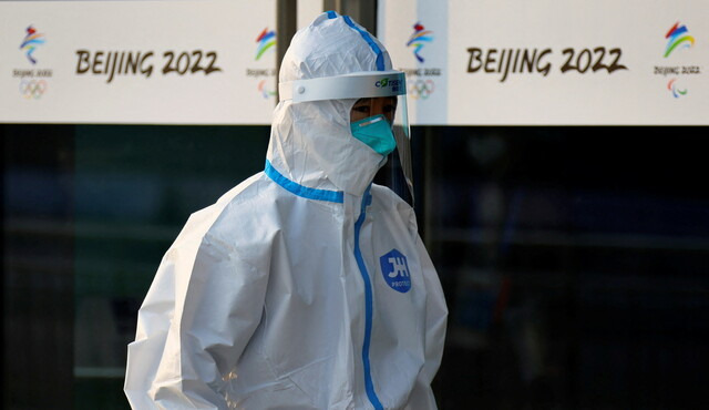방역복 차림의 의료진이 7일 베이징 겨울올림픽 미디어 센터 앞을 지나고 있다. 로이터/연합뉴스