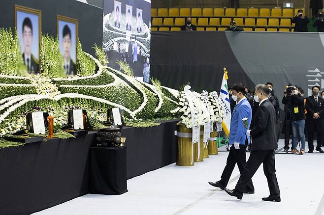 [평택=뉴시스]  8일 오전 평택 이충문화체육센터에서 경기도청장으로 마련된 故 이형석 소방경(50), 故 박수동 소방장(31), 故 조우찬 소방교(25)의 합동 영결식에서 문재인 대통령이 헌화를 하고 있다. (사진=경기도 제공) 2022.01.08. photo@newsis.com  *재판매 및 DB 금지