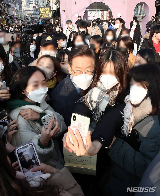 [서울=뉴시스] 국회사진기자단 = 이재명 더불어민주당 대선후보가 9일 오후 서울 마포구 홍대거리에서 시민들을 만나 기념촬영을 하고 있다. 2022.01.09. photo@newsis.com