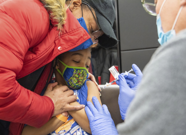 미국 펜실베이니아주 피츠버그 사우스사이드의 피츠버그대병원에서 엄마 품에 안긴 한 5세 아동이 겁에 질린 표정으로 코로나19 백신을 맞고 있다. /AP연합뉴스
