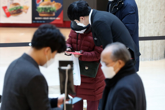 ▲10일 오전 서울 중구 롯데백화점 본점에서 직원들이 어르신들의 QR코드 인증을 도와드리고 있다.(사진=뉴시스)