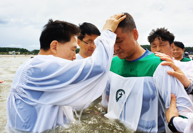 손문수(왼쪽) 동탄순복음교회 목사가 2019년 8월 충남 서천 춘장대해수욕장에서 열린 침례식에서 세례를 베풀고 있다.