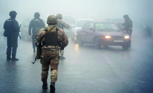집단안보조약기구(CSTO) 평화유지군 소속 군인들이 8일(현지시간) 안개가 자욱한 카자흐스탄 알마티 도로에서 불심검문을 하고 있다. AP연합뉴스