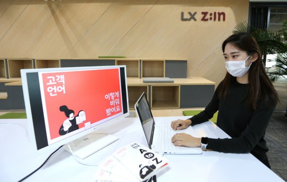 LX하우시스 직원이 'LX Z:IN 인테리어 고객 언어 가이드북'을 살펴보고 있다. LX하우시스 제공