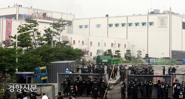 2009년 7월20일 경찰이 쌍용자동차 평택공장 내로 진입하자 노조원들이 구호를 외치고 있다. 경향신문 자료사진