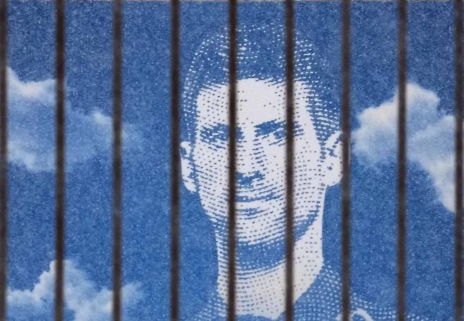 세르비아의 테니스 영웅 노바크 조코비치가 쇠창살 뒤에 갇힌 모습을 그린 옥외 광고판이 10일(현지시간) 세르비아 수도 베오그라드의 한 건물에 세워져있다.   베오그라드 | AP연합뉴스