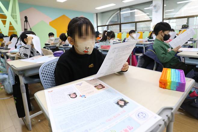 지난해 12월30일 오전 서울 중구 덕수초등학교에서 학생들이 방학 숙제와 개학 일정 등이 적힌 안내문을 보고 있다. [연합]