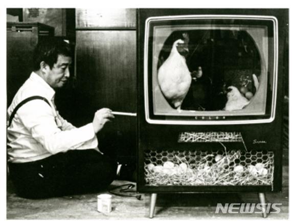 [서울=뉴시스]마크 패츠팰, 〈Chicken II 02〉에 사인하는 백남준, 1987, 종이에 흑백 프린트, 19x25cm, 백남준아트센터 마크 패츠팰 아카이브 컬렉션.