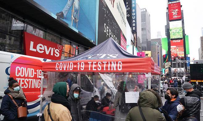 미국 뉴욕의 타임스퀘어에서 2021년 12월 28일(현지시간) 시민들이 코로나19 검사를 받기 위해 이동 검사소 앞에 서 있다. 뉴욕=AFP연합뉴스
