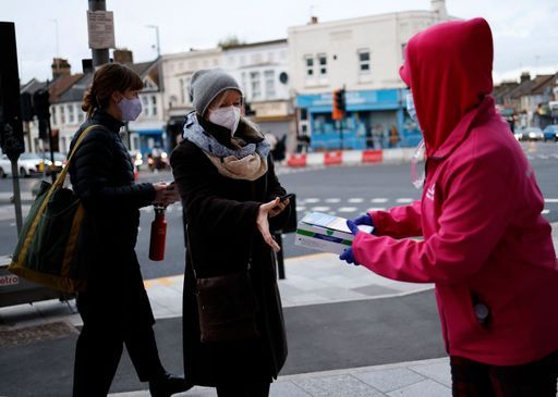 3일(현지시간) 영국 런던에서 한 자원봉사자가 시민들에게 코로나19 간이 검사기를 나눠주고 있다. 런던=AFP연합뉴스