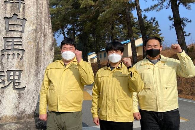 고속도로를 달리다 전복된 차량에서 일가족 4명을 무사히 구출한 육군35보병사단 예하 백마여단 예비군훈련대 소속 김태현, 윤대길, 김영민 군무주무관(왼쪽부터)이 부대 내 기념비에서 '백마'를 외치고 있다. 육군35사단 제공