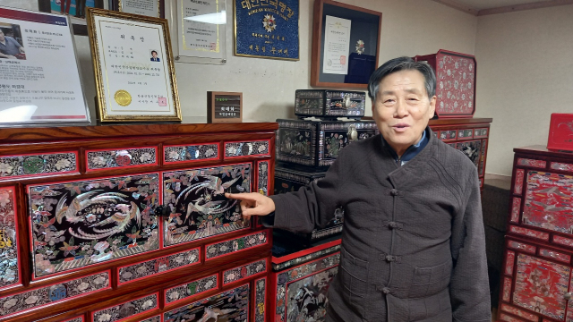 최태화 남해공예사 대표가 문·무·왕실을 표현하는 동물들을 소재로 만든 흉배문양 삼층장에 대해 설명하고 있다.