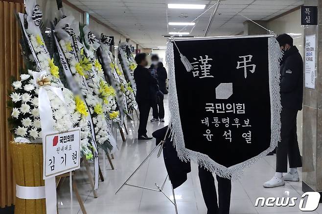 12일 오후 서울 시내의 한 병원에 마련된 이재명 더불어민주당 대선후보의 '변호사비 대납 의혹' 관련 녹취록을 처음 제보했던 이 모씨의 빈소 앞에서 윤석열 국민의힘 대선후보와 김기현 원내대표의 조화가 옮겨지고 있다.© News1 이승배 기자