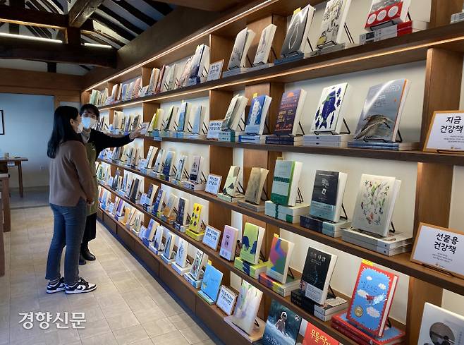 일일호일 건강백서 서가에서 내방객이 책을 고르고 있다.&nbsp;엔자임헬스 제공