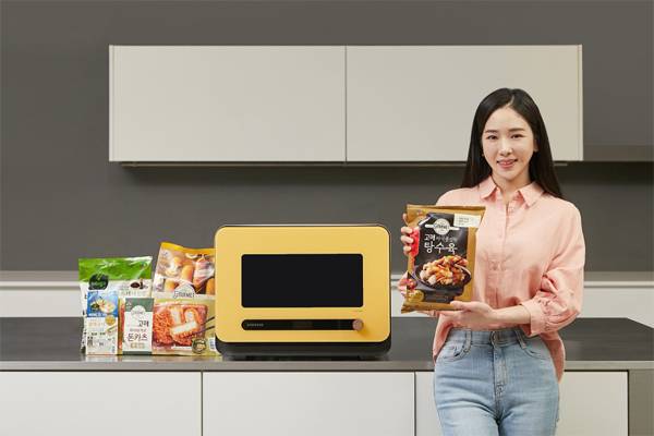 모델이 삼성전자 비스포크 큐커와 협력하는 CJ제일제당의 가정간편식(HMR) 제품들을 소개하고 있다. [사진 제공 = CJ제일제당]