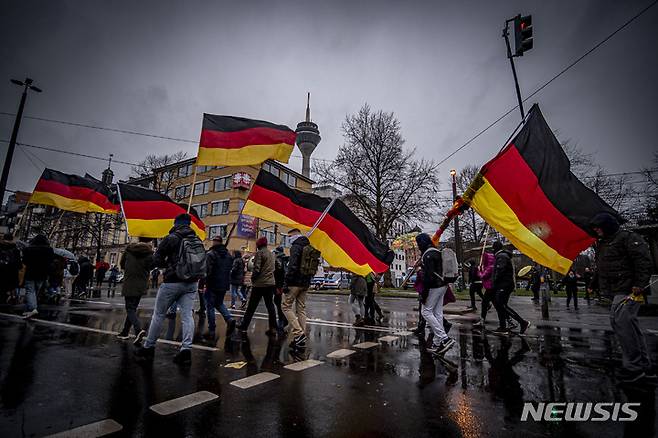 [뒤셀도르프=AP/뉴시스]8일(현지시간) 독일 뒤셀도르프에서 코로나19 제한 조치에 반대하는 시민들이 항의하는 시위를 벌이고 있다. 2022.01.09.
