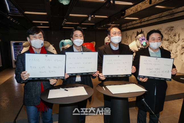 국민의힘 윤석열(왼쪽에서 세 번째)후보가 12일 ‘2022 LCK 스프링’ 개막전에 참석해 직접 쓴 방명록을 들어 보이고 있다. 왼쪽부터 국민의힘 하태경 게임특별위원장, 이준석 대표, 윤 후보, 원희룡 정책본부장. &nbsp;김민규 기자 kmg@sportsseoul.com