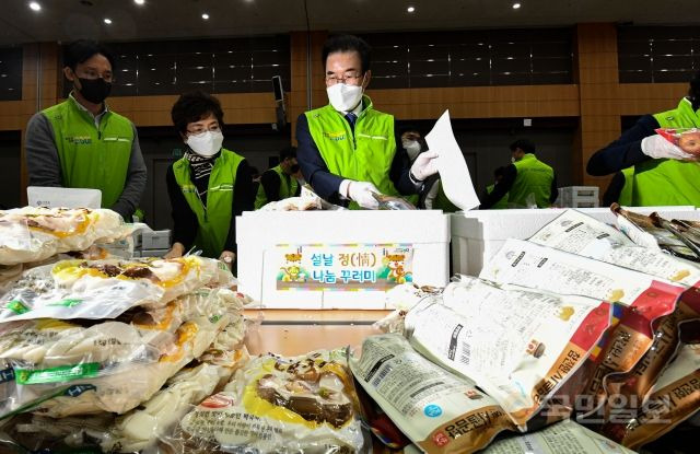 이성희 농협중앙회장이 13일 서울 중구 농협중앙회 본관에서 열린 '설날 정(情) 나눔 꾸러미' 행사에서 우리 농축산물 꾸러미를 포장하고 있다.