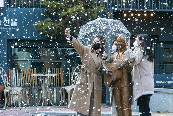 지난 13일 대구 중구 김광석길을 찾은 시민들이 인공눈을 만끽하며 즐겁게 사진을 찍고 있다. [사진=중구청]