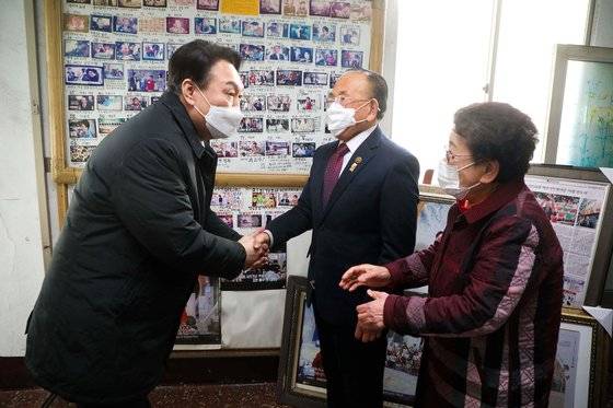 국민의힘 윤석열 대선 후보가 14일 창원시 신신예식장을 찾아 백낙삼ㆍ최필순 부부와 인사하고 있다.   신신예식장 백 대표는 55년 동안 무료 예식 봉사를 통해 1만4천200여 쌍의 결혼을 지원했다. [연합뉴스]