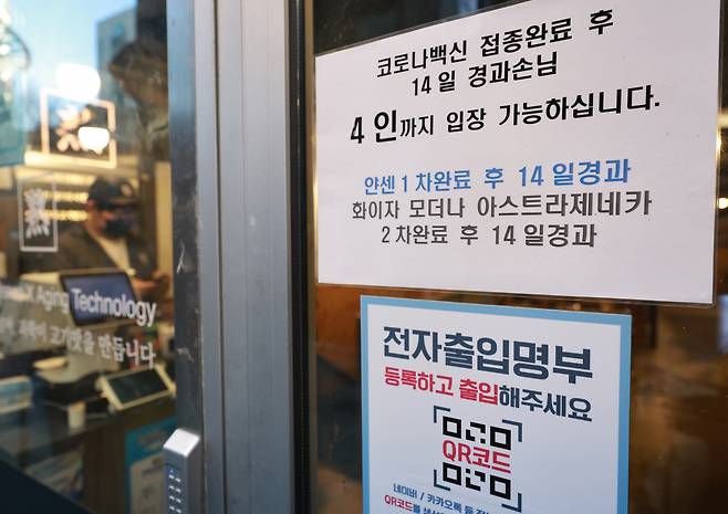 14일 오후 저녁 장사를 앞둔 서울 종로구의 한 식당 입구에 방역패스(백신접종증명·음성확인제) 관련 안내문이 부착돼 있다. [연합]