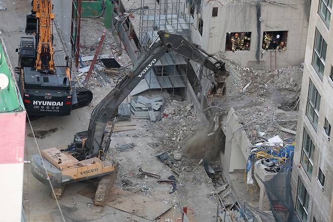 광주 서구 화정동 신축아파트 붕괴사고 나흘째인 14일 관계자들이 잔해물을 치우고 있다. [연합]